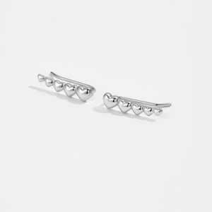 Macro detail of S925 sterling silver ear crawlers with five linked heart shapes