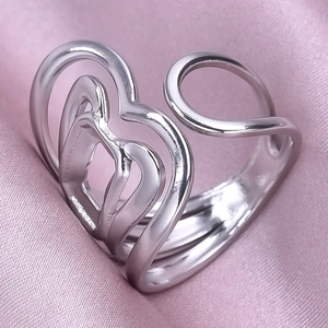 Vue macro d'une bague coeur argentée réglable posée sur un tissu en soie rose