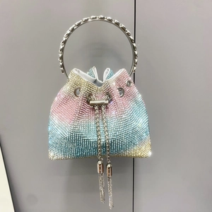 Dettaglio di strass sfumati colorati sulla borsa a secchiello con manico in metallo