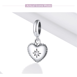 Close-up of S925 silver heart charm with starburst setting and clear cubic zirconia