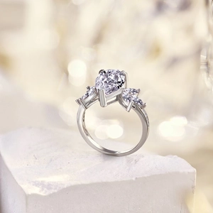Macro shot of a S925 silver ring featuring a pear-cut gemstone and brilliant accent stones
