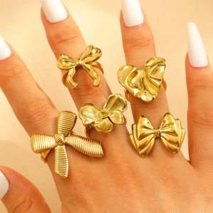 Detailed close-up of a five-piece gold bow and heart ring set worn on model hands