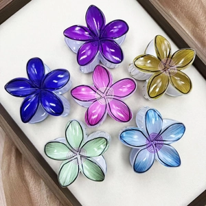 Set of six colorful plumeria flower hair claws in purple, blue, pink, and green