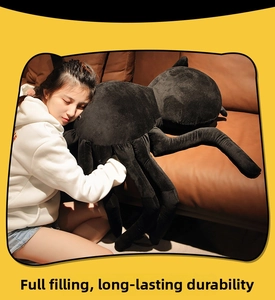 Close-up of a large black spider plush toy with soft texture and realistic long legs