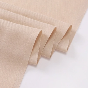 Close-up of beige cashmere-feel fabric texture with soft woven folds and draping