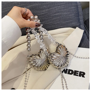 Detail of silver heart metal handbag featuring unique crystal beads and ball chain strap