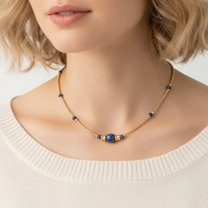 Minimalist gold beaded necklace featuring blue sodalite stones worn on a model