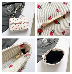 Detail view of white corduroy strawberry bag with gold hardware and chain strap