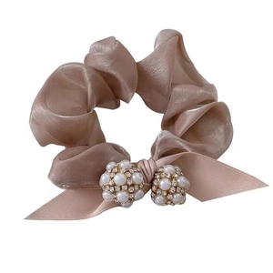 Chouchou élégant en organza mauve avec nœud en perles et strass sur fond blanc