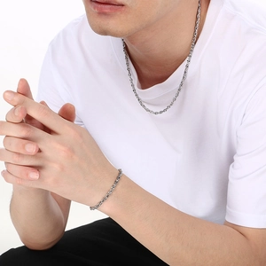 Close-up of stainless steel pig nose chain necklace and bracelet on male model