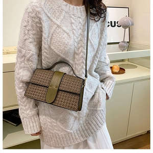 Brown woven crossbody bag with olive green leather details shown on a model