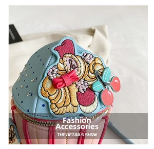Detail of cupcake shaped bag with floral embroidery and red 3D bow decoration