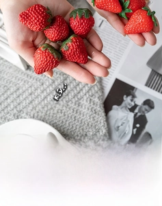 Close-up of realistic red artificial strawberries with green leaves for home decoration