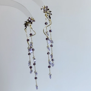 Vue détaillée d'élégantes boucles d'oreilles à pompons glycine violette et papillons