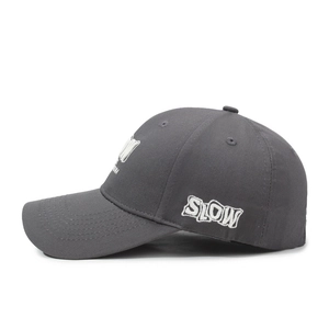 Dark grey baseball cap with white SLOW embroidery and curved brim in side view