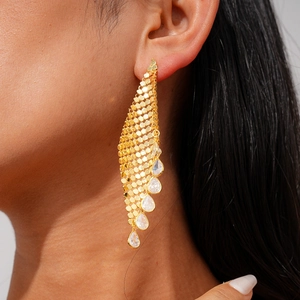 Détail de boucles d'oreilles pendantes en or 18 carats avec cinq pierres de zircon