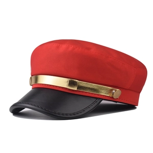 Détail du chapeau plat rouge avec bord en similicuir noir et galon doré chic