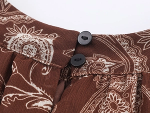 Dettaglio dello scollo in chiffon paisley marrone con due piccoli bottoni neri