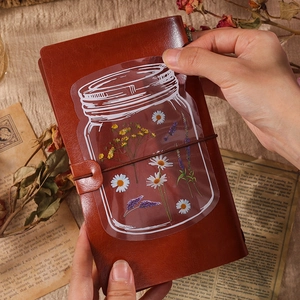 Vintage floral PET stickers with daisy and lavender designs on a leather journal