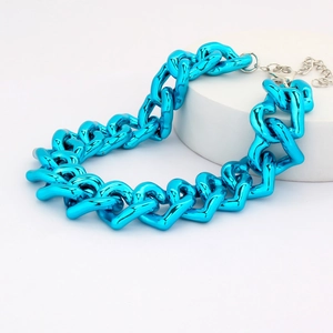 Detail of the bright blue heart link chain necklace on a white platform