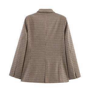 Macro shot of the brown and black houndstooth pattern texture on women's blazer back