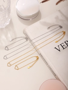 Macro detail of gold and silver heart pendants with white zircon on jewelry set