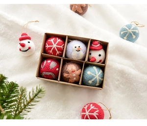 Macro shot of wool felt Christmas ornaments with snowflake and snowman in a kraft box