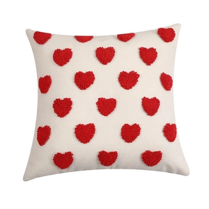 Close-up of tufted red heart patterns on cream polyester-cotton throw pillow case