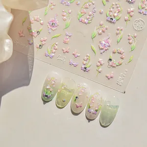 Macro view of 3D embossed pink lily of the valley nail stickers with butterfly details
