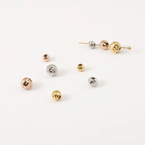 Macro detail of hammered stainless steel beads in gold silver and rose gold finishes