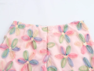 Detail eines rosa Rocks mit 3D-Blumenapplikationen, Pailletten und einem verdeckten Reißverschluss