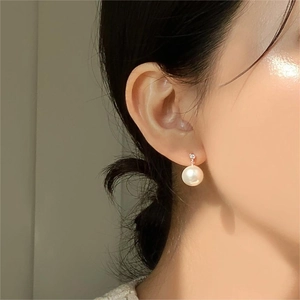 Close-up of elegant S925 silver pearl earring with zircon stud on model ear