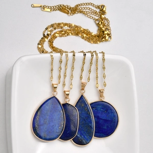 Détail de pendentifs en lapis-lazuli bleu en forme de goutte sur des chaînes dorées