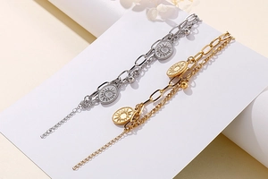 Detail of double-layer stainless steel bracelets with sun and moon oval pendant charms