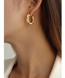 Close-up of chunky gold twisted hoop earrings with a polished 18K gold plated texture