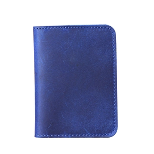 Detail showing deep blue leather card holder with premium hand-stitched craft edges