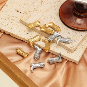 Pendentifs bottes dorés et argentés pour colliers sur pierre beige et tissu de soie dorée