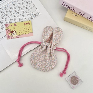 Detailed view of pink floral drawstring storage bag with cute rabbit ear decoration