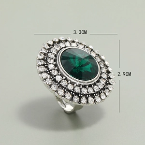 Macro detail of vintage green stone ring with rhinestone border and 3.3x2.9cm dimensions