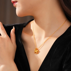 Detailed close-up of a gold-plated dragon pendant necklace worn by a model in soft light