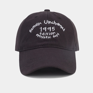 Close-up of vintage athletic embroidery on a black cotton twill baseball cap