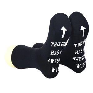 Detail of black cotton socks featuring white 'THIS GUY HAS AN AWESOME WIFE' printed text