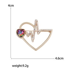 Elegant gold heart brooch with rhinestone heartbeat line and a colorful faceted gem