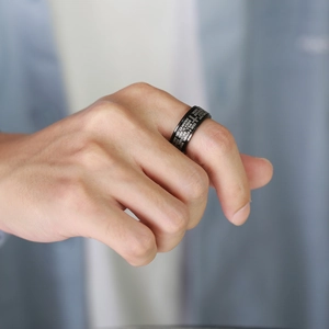 Close-up of black stainless steel spinner ring with engraved Bible prayer and cross
