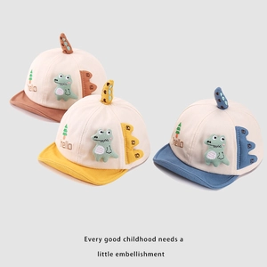 Detailed view of baby baseball caps with soft dinosaur horns in brown, yellow, and blue colors