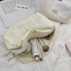Detail view of cream floral lace makeup bag showing spacious interior and soft fabric texture
