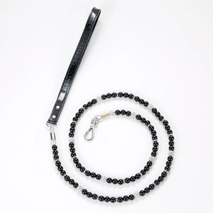 Detailed macro view of black pearl pet leash with diamond accents and leather handle