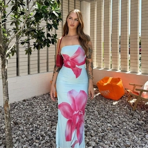 Detail of light blue strapless maxi dress featuring vibrant pink floral prints and a side slit