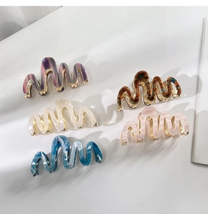 Macro view of five wavy acetate hair claws in marble and tortoiseshell patterns