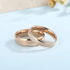 Macro view of rose gold couple rings with polished finish on a light blue surface